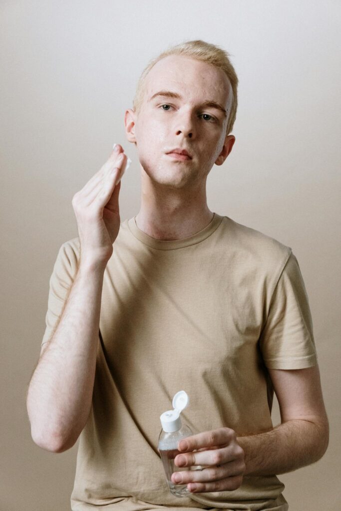 Young man applying cleanser in a skincare routine for healthy, hydrated skin.
